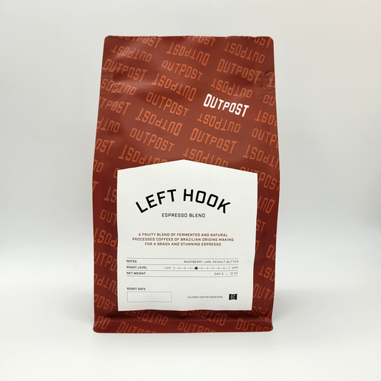 A package of Outpost Left Hook Espresso blend coffee, with a white label on a brown background featuring product information.